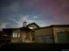 Eye-catching exterior view of a modern home with a stone chimney and a two-car garage at night at 12947 Lazy Dog Ln, Littleton, CO 80127