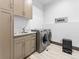 Convenient laundry room with modern washer and dryer, ample cabinet space, and stylish countertops at 12947 Lazy Dog Ln, Littleton, CO 80127