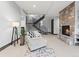 Stylish living room featuring a stone fireplace, modern staircase, and comfortable seating area at 12947 Lazy Dog Ln, Littleton, CO 80127