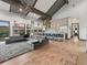 Open-concept living room flowing into a kitchen with a vaulted ceiling and exposed beams at 12947 Lazy Dog Ln, Littleton, CO 80127