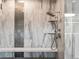 Close-up of the marble tiled shower with a built-in bench and modern shower head at 12947 Lazy Dog Ln, Littleton, CO 80127