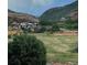 Scenic view of mountains with a vibrant landscape, trees, and a rainbow at 12947 Lazy Dog Ln, Littleton, CO 80127