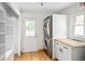 Well-organized laundry room featuring a modern washer-dryer, wooden countertop, storage, and convenient access to outdoors at 2680 S Garfield Cir, Denver, CO 80210