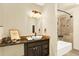 Bathroom with granite vanity, elegant light fixture, tub and shower combo at 7755 E Quincy Ave # 206, Denver, CO 80237