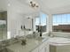 Sun-filled bathroom featuring double vanity, tub, shower, decorative tile, and large windows at 22263 Boundstone St, Parker, CO 80138