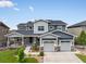 Attractive two-story home boasts stone accents, manicured landscaping, and a three-car garage under a clear blue sky at 22263 Boundstone St, Parker, CO 80138