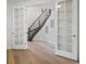 Welcoming hallway entrance featuring hardwood floors and French doors that open to a beautiful staircase at 22263 Boundstone St, Parker, CO 80138