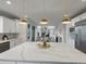 Open-concept kitchen with stone counters, stainless appliances, and dining area with a fireplace at 22263 Boundstone St, Parker, CO 80138