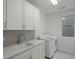 Well-organized laundry room featuring quartz countertops, shaker cabinets and modern washer and dryer units at 22263 Boundstone St, Parker, CO 80138