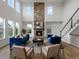 Spacious living room showcasing a stone fireplace, tall windows, and views of the staircase at 22263 Boundstone St, Parker, CO 80138
