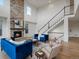 The living room boasts a stone fireplace and a soaring ceiling, adjacent to the elegant staircase at 22263 Boundstone St, Parker, CO 80138