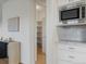 View of the pantry with custom shelving and modern microwave in a well-lit kitchen at 22263 Boundstone St, Parker, CO 80138