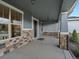 Inviting covered porch featuring stone accents, stylish lighting, and ample space for relaxing on outdoor furniture at 22263 Boundstone St, Parker, CO 80138