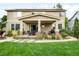 Landscaped backyard with a covered patio, stone pillars, and outdoor seating area at 15348 W 75Th Pl, Arvada, CO 80007