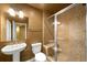 Well-lit bathroom with tiled shower, glass door, neutral vanity, and matching fixtures at 15348 W 75Th Pl, Arvada, CO 80007