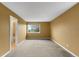 Empty bedroom with neutral carpet and paint and a window overlooking the yard at 15348 W 75Th Pl, Arvada, CO 80007