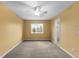 Bedroom features neutral carpeting, a ceiling fan, and a window with scenic views at 15348 W 75Th Pl, Arvada, CO 80007