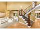 Grand entryway with hardwood floors, staircase, and views into the formal living and dining spaces at 15348 W 75Th Pl, Arvada, CO 80007