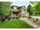 Charming two-story home with stone accents, landscaped yard, and inviting front porch at 15348 W 75Th Pl, Arvada, CO 80007
