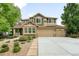Charming two-story home with three-car garage, stone accents, and beautifully landscaped front yard at 15348 W 75Th Pl, Arvada, CO 80007