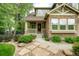 Inviting front porch and walkway, complemented by a stone exterior and lush landscaping at 15348 W 75Th Pl, Arvada, CO 80007
