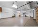 Spacious three car garage with epoxy flooring, storage cabinets, and bicycle hoist at 15348 W 75Th Pl, Arvada, CO 80007