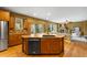 Spacious open kitchen showcases large center island, stainless steel appliances, and hardwood floors at 15348 W 75Th Pl, Arvada, CO 80007