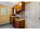Cozy laundry room featuring custom cabinetry, tile backsplash, and a sink with elegant fixtures at 15348 W 75Th Pl, Arvada, CO 80007