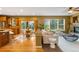 Open-concept living area with views into kitchen, bright windows, comfortable seating, and fireplace at 15348 W 75Th Pl, Arvada, CO 80007