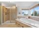 Bright main bathroom with a separate shower, tub, and a large window bringing in natural light at 15348 W 75Th Pl, Arvada, CO 80007
