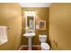 Charming powder room featuring a pedestal sink, decorative mirror, and stylish fixtures at 15348 W 75Th Pl, Arvada, CO 80007