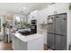 Well-lit kitchen boasts white cabinetry, modern appliances, a stylish backsplash, and an island with a stovetop at 613 N Brentwood Ct, Castle Rock, CO 80104