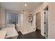 Modern bathroom with soaking tub, glass shower, black fixtures, and window at 6358 S Miller Way, Littleton, CO 80127