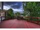 View of the wood deck, overlooking fenced-in backyard and mature trees at 6358 S Miller Way, Littleton, CO 80127