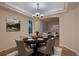 This formal dining room features a wood table, six chairs, and a tray ceiling at 6358 S Miller Way, Littleton, CO 80127