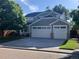 Two-story home boasts a gray exterior, a two-car garage, charming porch, and mature landscaping at 6358 S Miller Way, Littleton, CO 80127