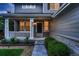 Inviting front porch with decorative columns, hanging plants, and manicured landscaping leading to front door at 6358 S Miller Way, Littleton, CO 80127