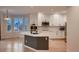 Spacious kitchen with white cabinetry, stainless appliances, and an island, complemented by natural light at 6358 S Miller Way, Littleton, CO 80127