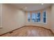 Bright living room showcasing hardwood floors, light walls, and large windows with plantation shutters at 6358 S Miller Way, Littleton, CO 80127