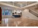 Spacious open-concept living room with hardwood floors, modern kitchen, and staircase with decorative railings at 6358 S Miller Way, Littleton, CO 80127