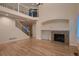 Bright living room features hardwood floors, high ceilings, a fireplace, and an open staircase with iron railings at 6358 S Miller Way, Littleton, CO 80127