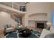Bright living room with fireplace, hardwood floors, and ample seating and an upper level balcony at 6358 S Miller Way, Littleton, CO 80127