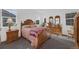 Bedroom with a wooden bed frame, dresser, and carpet flooring at 1680 Rivergate Way, Berthoud, CO 80513