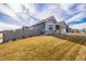 Side view of a house with gray siding, landscaping, and a fenced yard at 1680 Rivergate Way, Berthoud, CO 80513