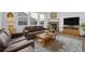 Living room with fireplace, brown leather couches, and wood coffee table at 1680 Rivergate Way, Berthoud, CO 80513