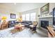 Living room with fireplace, brown leather couches, and wood coffee table at 1680 Rivergate Way, Berthoud, CO 80513