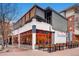 Multi-story building featuring outdoor seating, awnings, red window trim, and an inviting exterior at 100 Park W Ave # 201, Denver, CO 80205