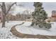 The community features a well-maintained, snow-covered common ground with mature trees and walkways at 100 Park W Ave # 201, Denver, CO 80205