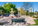 Picturesque park with a fountain, a bench, lush greenery, and city buildings in the background at 100 Park W Ave # 201, Denver, CO 80205