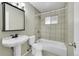 Bathroom features a pedestal sink, toilet, and tiled shower-tub combination at 6990 Larsh Dr, Denver, CO 80221